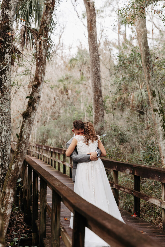 Bride and groom hugging during their first look at Highlands Hammock State Park.