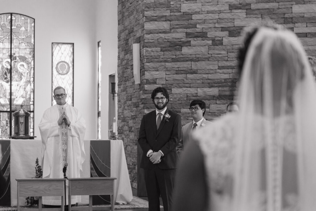 bride walking down the aisle to her groom in a Catholic church