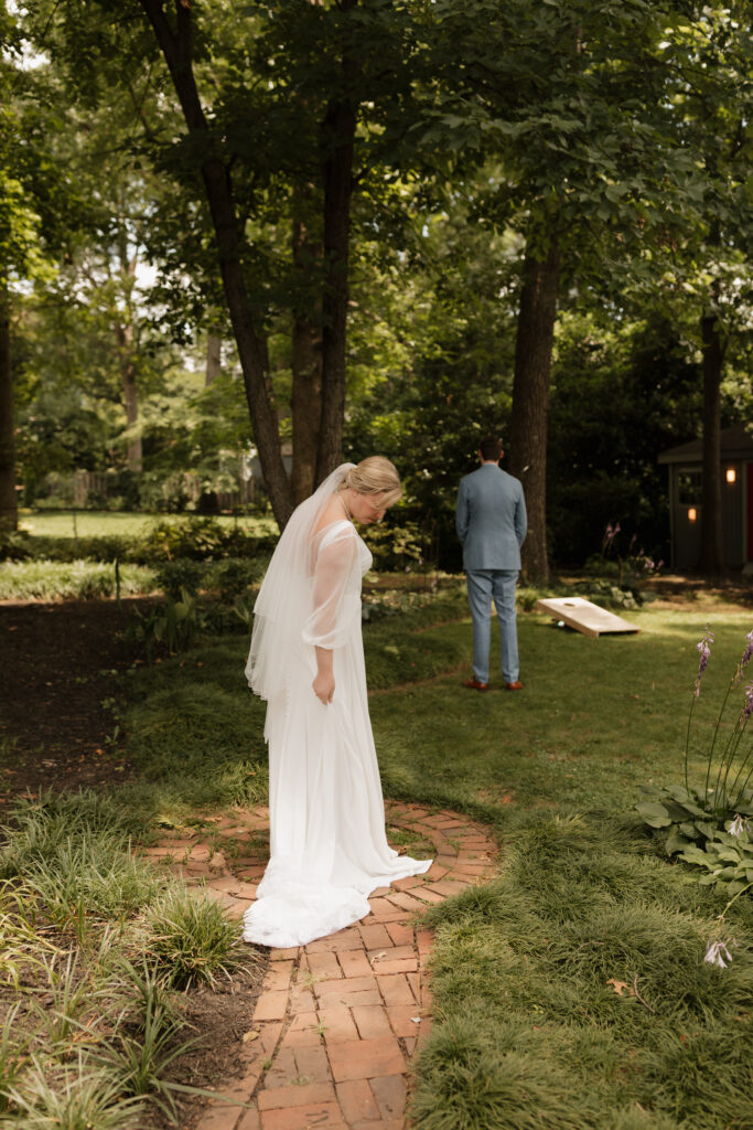 Bride adjusting her dress before her first look with her groom on their summer wedding day in downtown Greenville