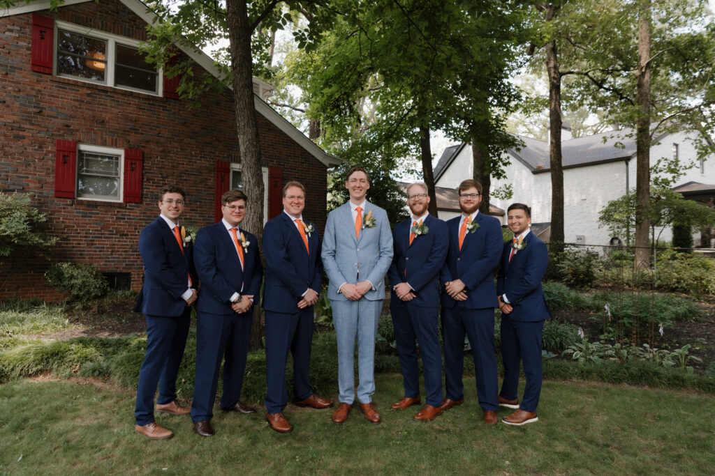 Groom with his groomsmen wearing blue and orange accents on a summer wedding day in downtown Greenville.