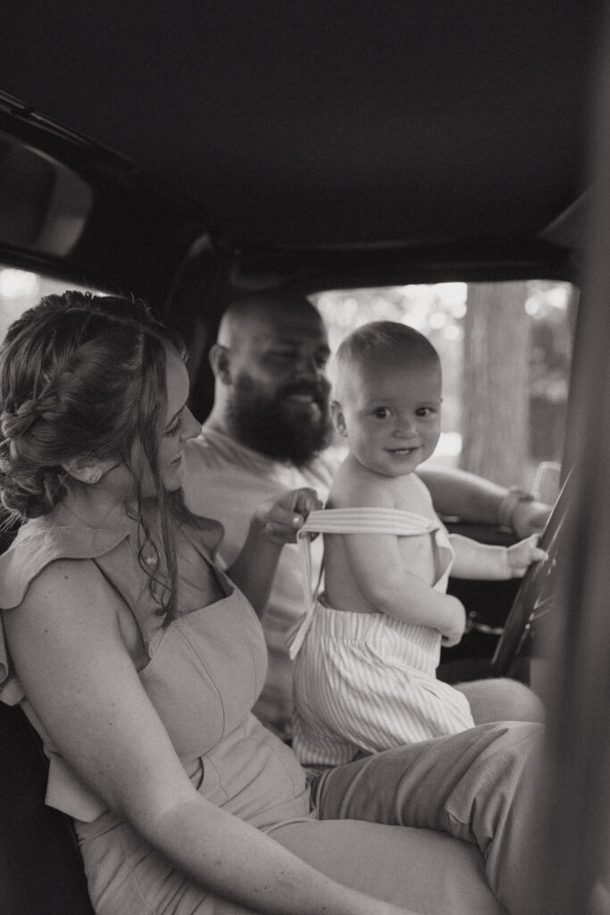 A couple with their toddler inside of a classic Ford F-150.
