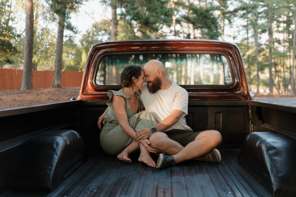 A couple during their engagement session in the bed of a classic Ford F-150.
