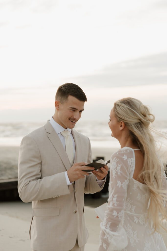 Bride and groom reading vows to each other during their elopement on Folly Beach in South Carolina.