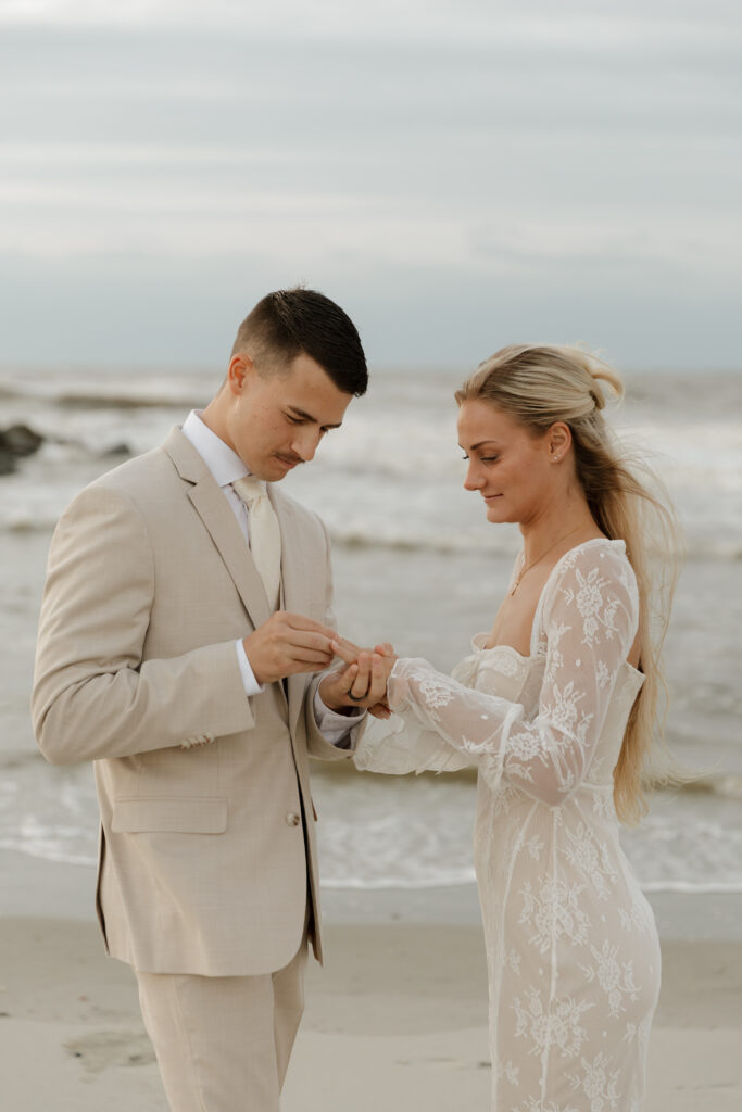 Bride and groom exchanging rings during their sunrise elopement on Folly Beach in South Carolina.