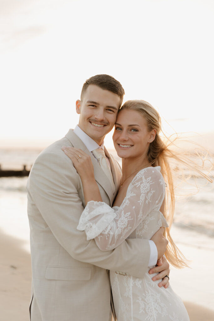 Bride and groom smiling for a portrait during their sunrise elopement on Folly Beach in South Carolina.