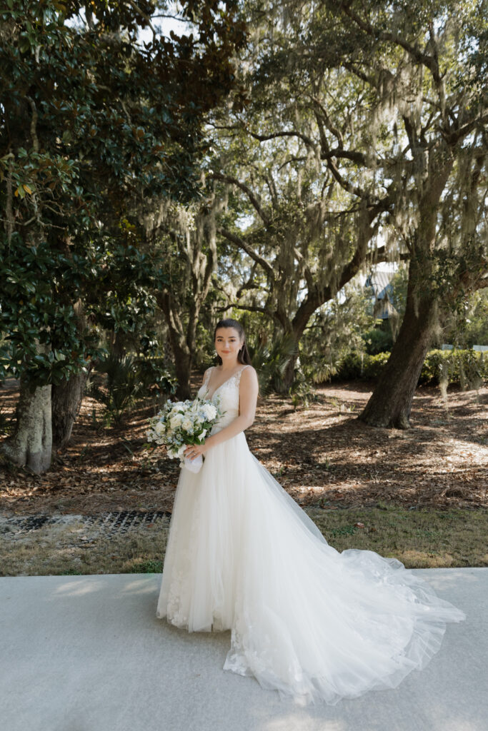 Bride standing under live oak trees with Spanish moss at The Golf Club at Briar's Creek on Johns Island, SC.