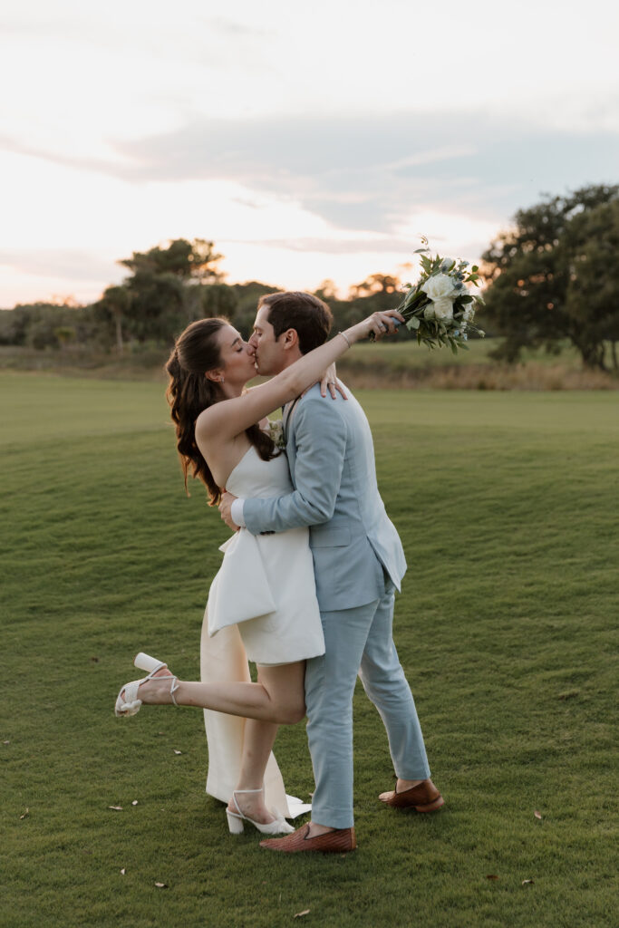 Bride and groom sharing a kiss as the sun is setting over the golf course at The Golf Club at Briar's Creek on Johns Island, SC.